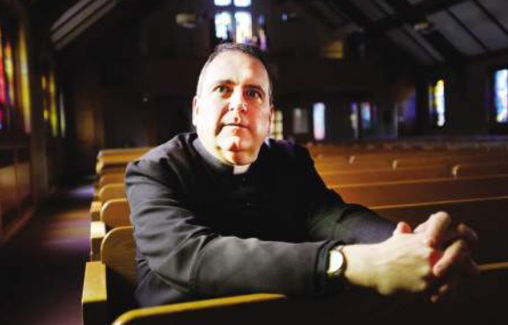 Father Gary Belliveau sitting in a church pew.