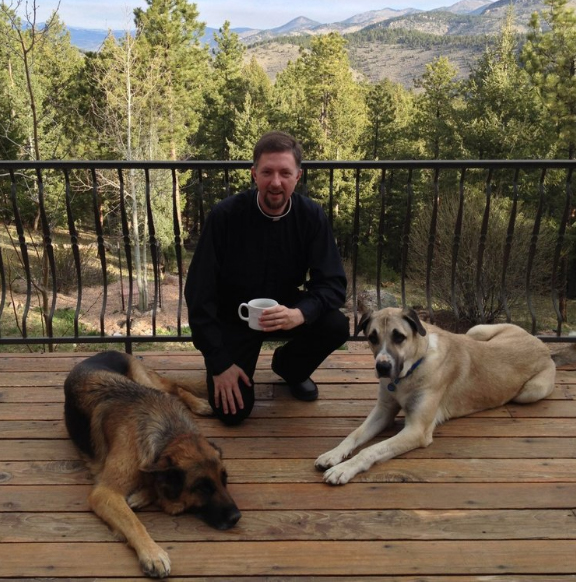 Father Brendan Rolling, O.S.B with two dogs.